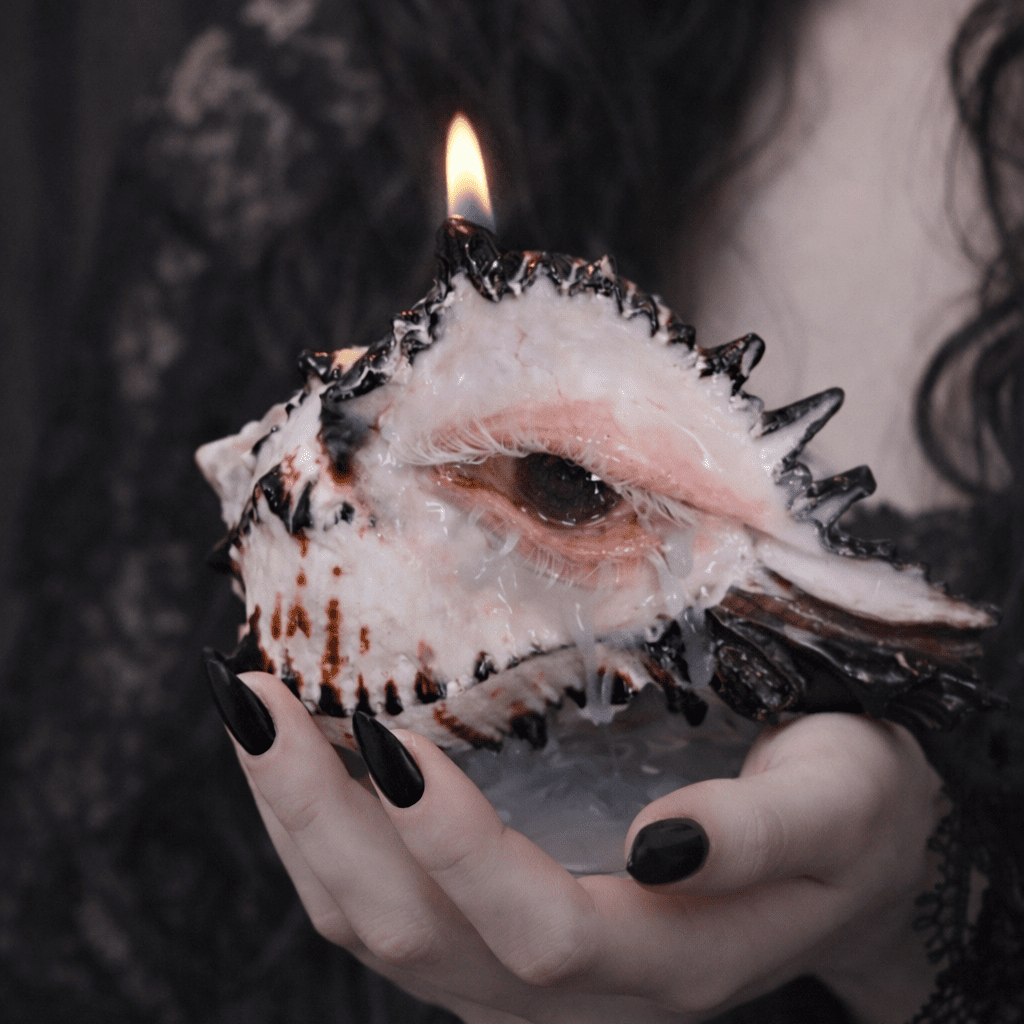 Angled view of conch shell candle holder with sculpted eye and exposed shell ridges