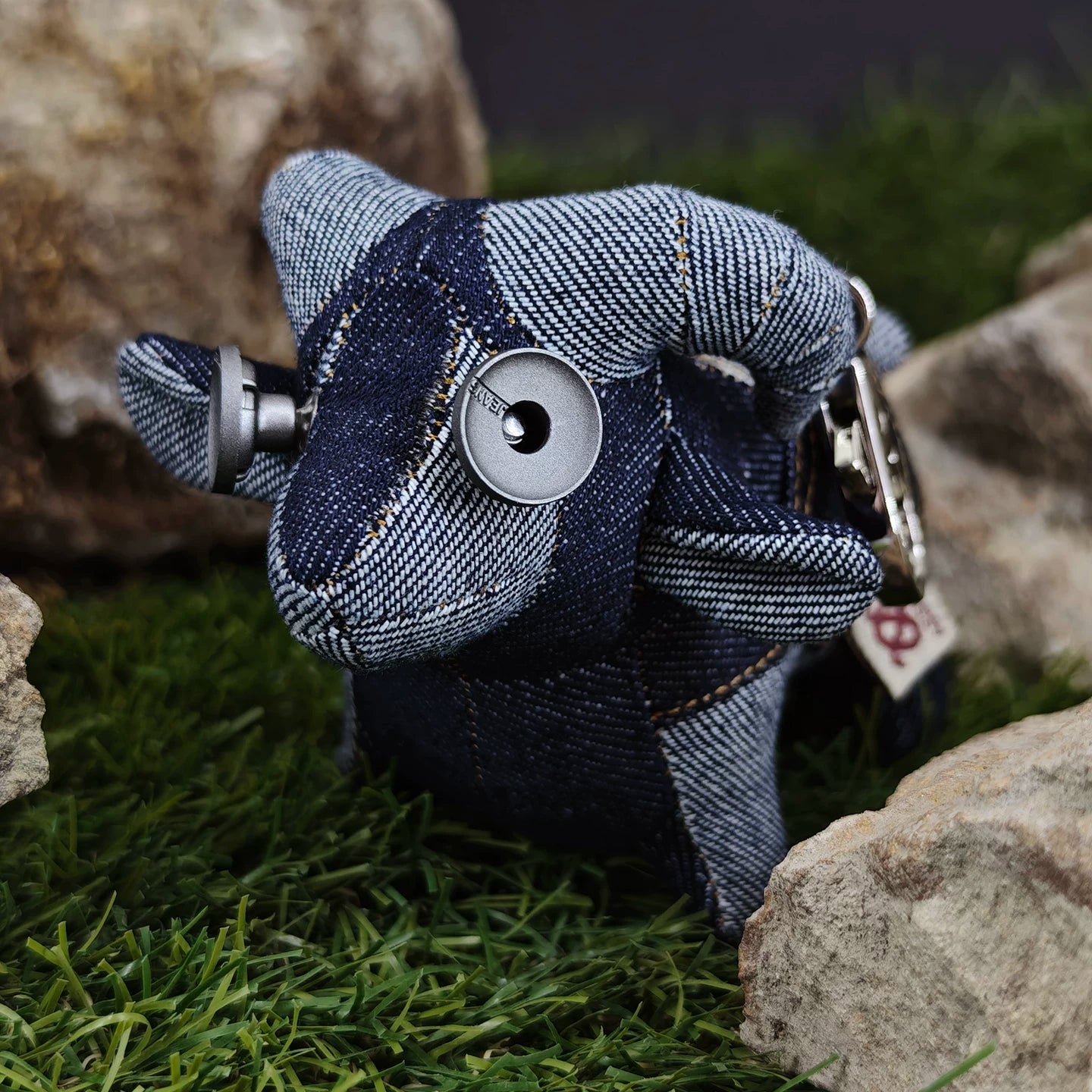 Denim lamb plush showing blue-gray curly fleece texture and orange stitching. Gothic rustic artisan craft, dark folk art collectible.