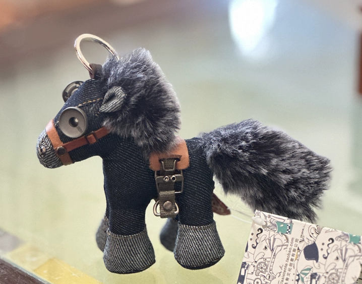 Artisan denim horse with fluffy gray mane, metal button eyes, and leather bridle. Gothic folk art style, macabre craft collectible.