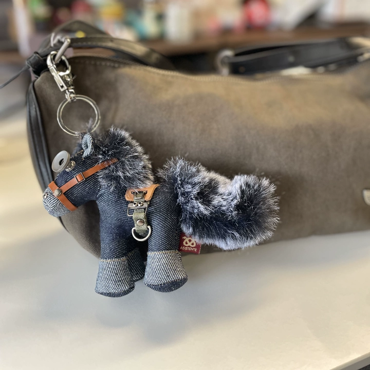 Denim horse figure featuring bold stitching and metal hardware details. Gothic artisan keychain, dark rustic folk art.