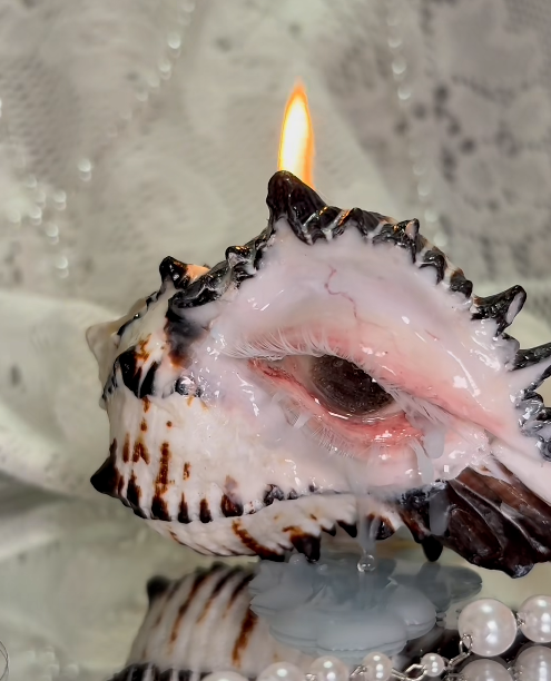 Close-up view of sculpted clay eye detail on conch shell surface