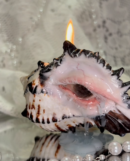 Close-up view of sculpted clay eye detail on conch shell surface