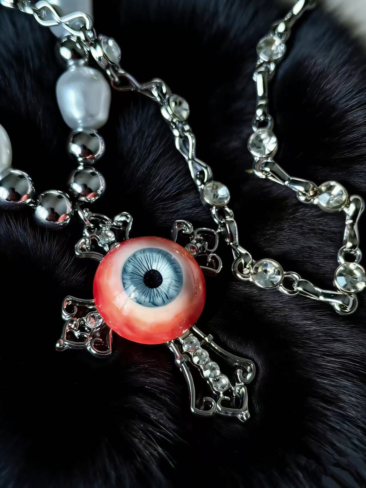 Handmade gothic eyeball pendant necklace with pearl chain on black background