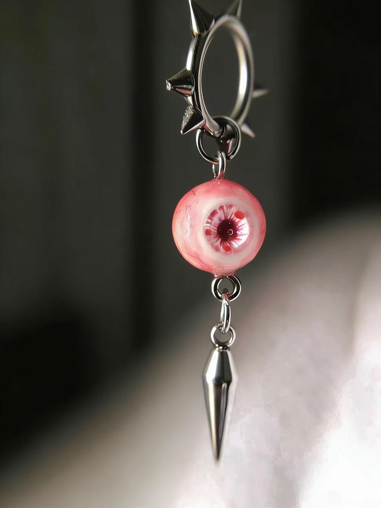Handmade spiked hoop earrings featuring realistic pink eyeball resin charms