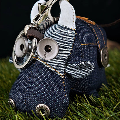 Peculiar miniature ox figurine in dark indigo with golden stitching accents. Gothic artisan keychain, dark folk art collectible.