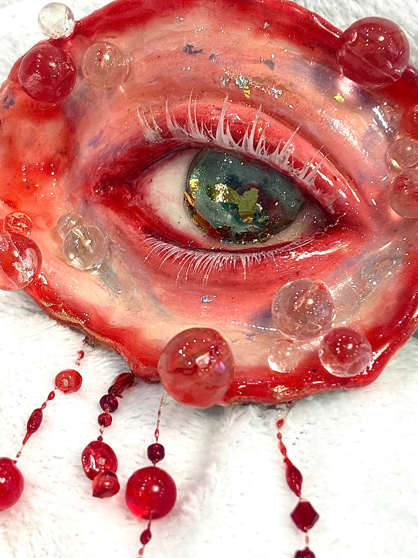 Side view of surreal red eye sculpture for dark art home décor