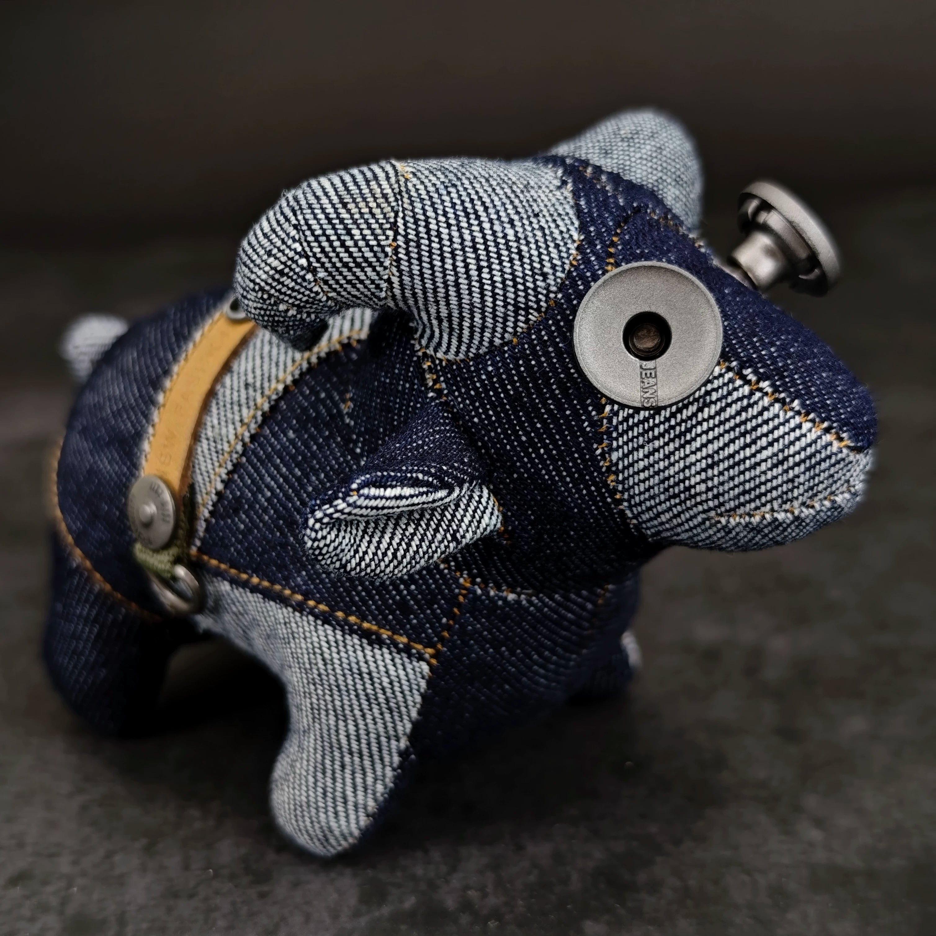 Indigo denim lamb with curly wool texture and weathered metal button. Dark artisan craft, gothic folk art keychain.