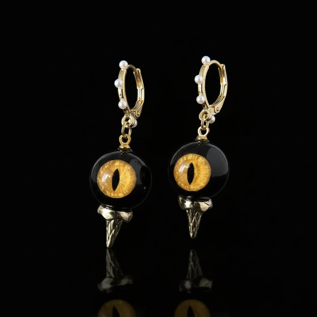 Pair of obsidian feline cat eye abyssal spike drop earrings on solid black background