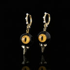 Pair of obsidian feline cat eye abyssal spike drop earrings on solid black background