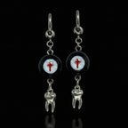 Pair of gothic crimson cross faux eyeball tooth charm drop earrings on solid black background