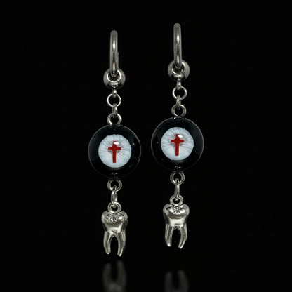 Pair of gothic crimson cross faux eyeball tooth charm drop earrings on solid black background