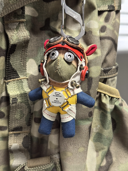 Pilot dog figure in gothic aviator gear with leather jacket and metal goggles. Macabre artisan art toy, dark vintage collectible keychain.