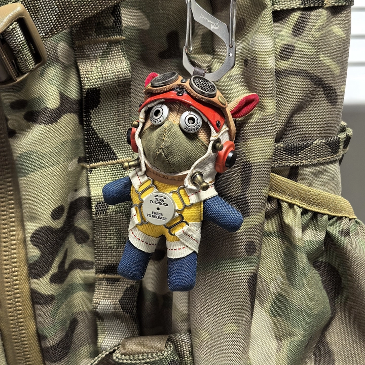 Dark gothic pilot dog with vintage leather cap and aviation goggles. Artisan macabre art toy, dark vintage collectible.