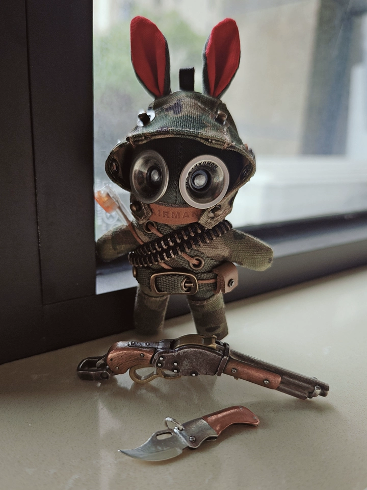 Camo tactical bunny with goggled aviator helmet and military bandolier. Dark gothic artisan art toy, wasteland macabre collectible.