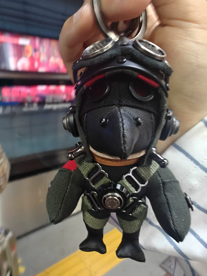 Handmade Bird Pilot Dark Version detail view — close-up of handcrafted fabric texture and red accent eyes, artisan toy — Awhisker