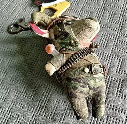 Military camo lamb with dark fabric texture and artisan detailing. Gothic artisan keychain, dark macabre folk art collectible.