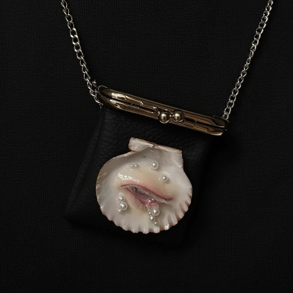 A black pebbled leather kiss-lock purse with three surreal shell eye embellishments featuring blue irises and white eyelashes, a gold-toned clasp, and a silver chain strap displayed against a dark background